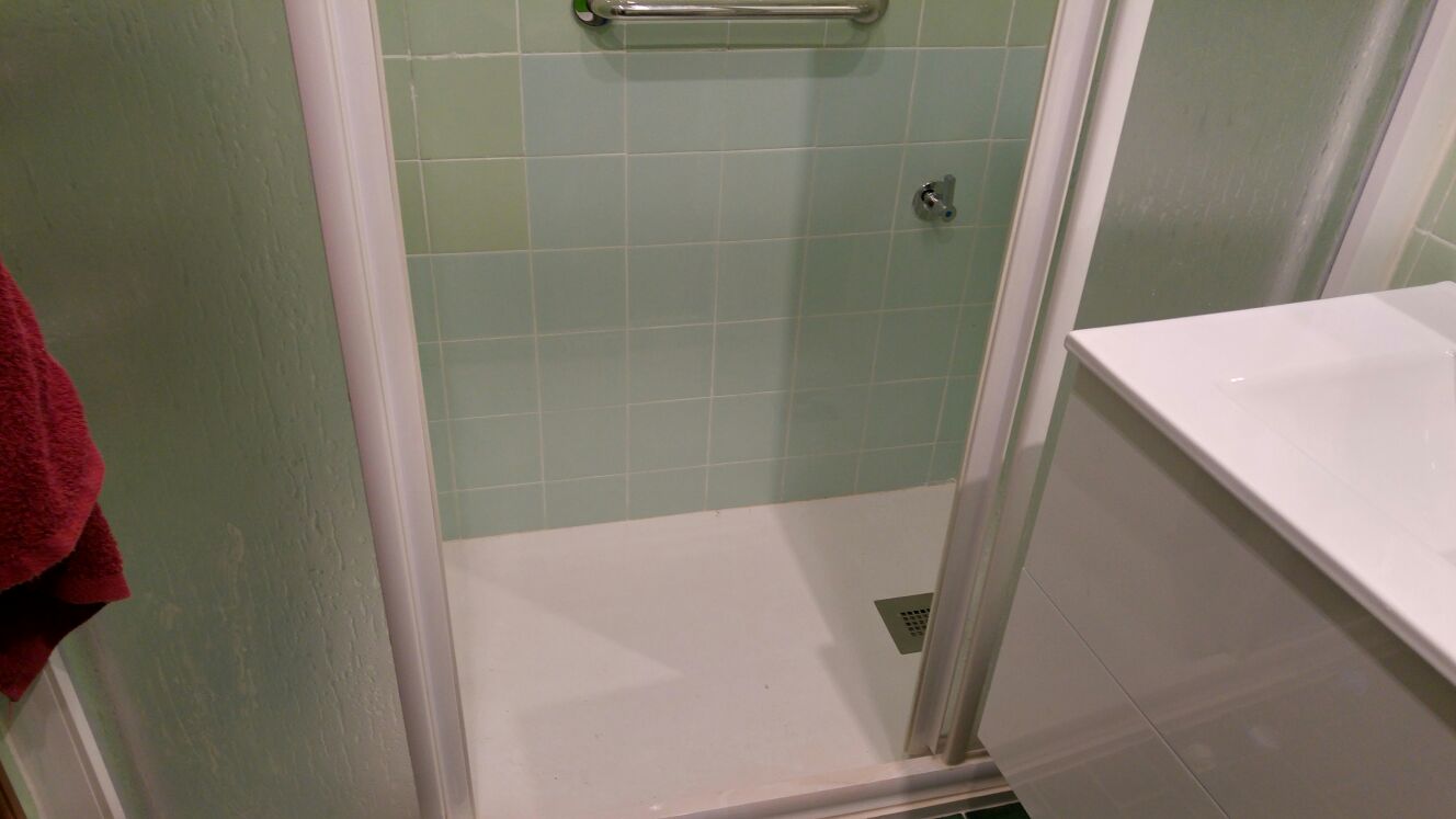 El mismo baño después: plato de ducha a ras de suelo con barra de agarre